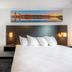 Independence Stay Hotel and Long term suites in Houghton: guest room with king bed, desk, chair and wall art