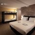 Hotel Orion Ghent room with double bed and bunk bed, warm lighting and textured wall