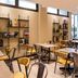 ibis Paris Alésia Montparnasse 14ème breakfast lounge in Paris with tables, chairs and leafy wall decor