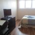 College Park Bed & Breakfast Saskatoon guest room with bed, desk, chair and TV by a bright window