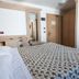 Hotel Sporting in Breuil-Cervinia bedroom with patterned bedspread, wooden wardrobe and desk