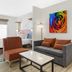 Best Western Plus Rose City Conference Center Inn in Thomasville guest room with gray sofa and colorful wall art