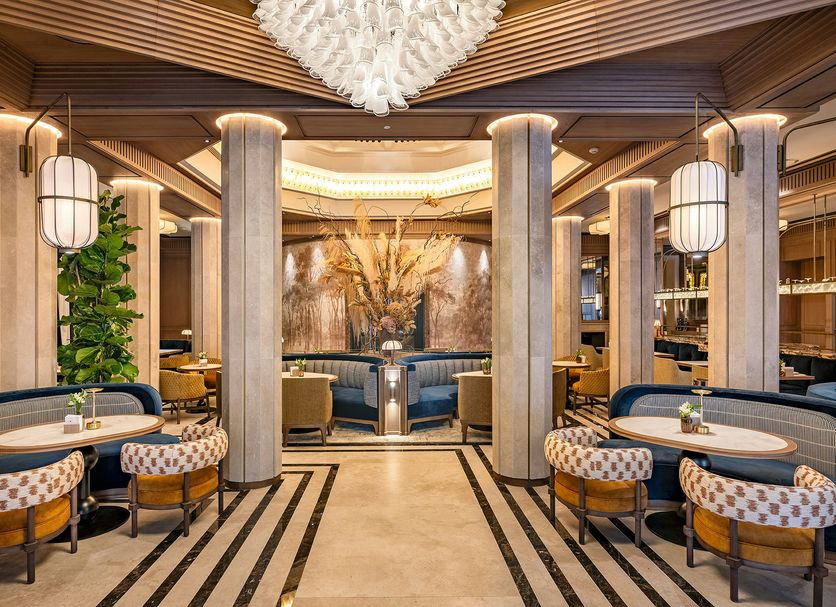 BLESS Hotel Madrid lobby lounge with round seating, marble columns and chandelier in Madrid