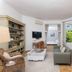 Hotel Mas Djoliba in Antibes: bright lounge with wicker seating, sofa, TV and open French doors to greenery