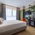 iH Hotels Milano Watt 13 guest room in Milan with bed, desk, orange chair and window.