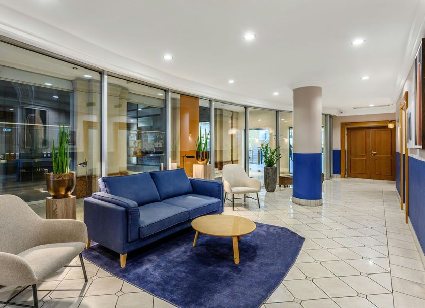 Millennium Court, Budapest - Marriott Executive Apartments lobby with blue sofa, chairs and glass walls in Budapest