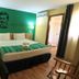 Hotel Santa Maria in Praia guest room with double bed, green accent wall, and balcony door