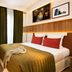 Hotel Eiffel Turenne in Paris guest room with double bed, green curtains, and wall art