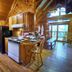 A Cabin In The Woods in Pigeon Forge kitchen with wood-paneled walls, stove, fridge and lofted cabin interior
