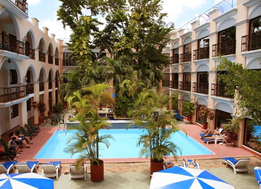 Hotel Doralba Inn in Mérida courtyard pool surrounded by palm trees and balconies