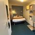 Contact Hôtel les Platanes Villeneuve sur Lot Centre room with bed, desk and wall shelves in Villeneuve-sur-Lot