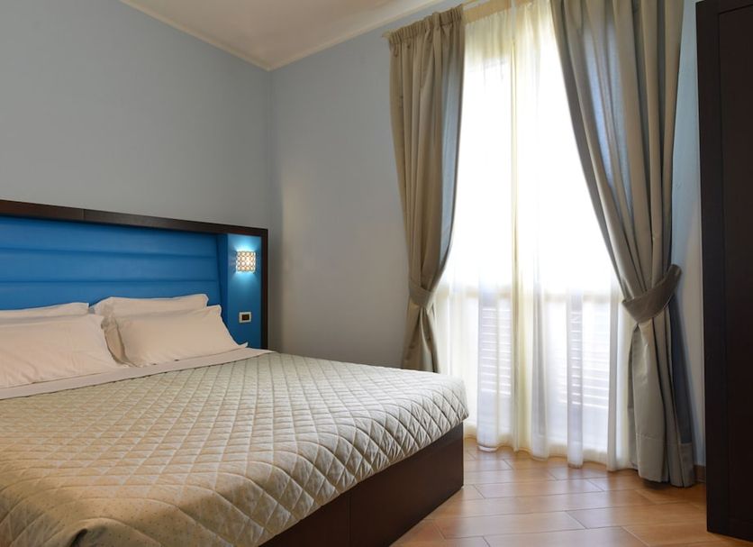Hotel Rosignano in Rosignano Solvay: bright guest room with bed and floor-to-ceiling window