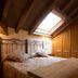 Hotel Naranjo De Bulnes room in Las Arenas with sloped wood سقiling, skylight, and wrought-iron bed