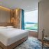 Expo Garden Resort Hotel Jinan guest room with king bed and large window overlooking green landscape