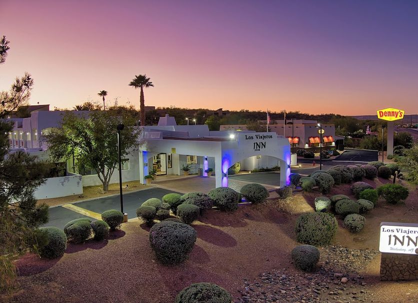 Los Viajeros Inn in Wickenburg at sunset with landscaped grounds and Denny's sign nearby