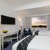 Aryaduta Makassar guest room with twin beds and sunset view over Makassar