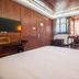 Changle Inn in Yangzhou guest room with wood-paneled walls, TV, desk, and window seating area