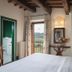 Relais Poggio Borgoni bedroom with balcony view of the Tuscan hills in San Casciano Val Di Pesa