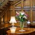Tre-Ysgawen Hall & Spa in Llangefni, wood-paneled hall with staircase, table lamp and flower arrangement