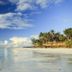 Baobab Beach Resort & Spa in Ukunda with a calm beach, palm trees, and ocean under a blue sky