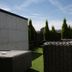 Hotel Colvenier in Antwerp terrace with wicker seating, artificial grass, and tall potted trees