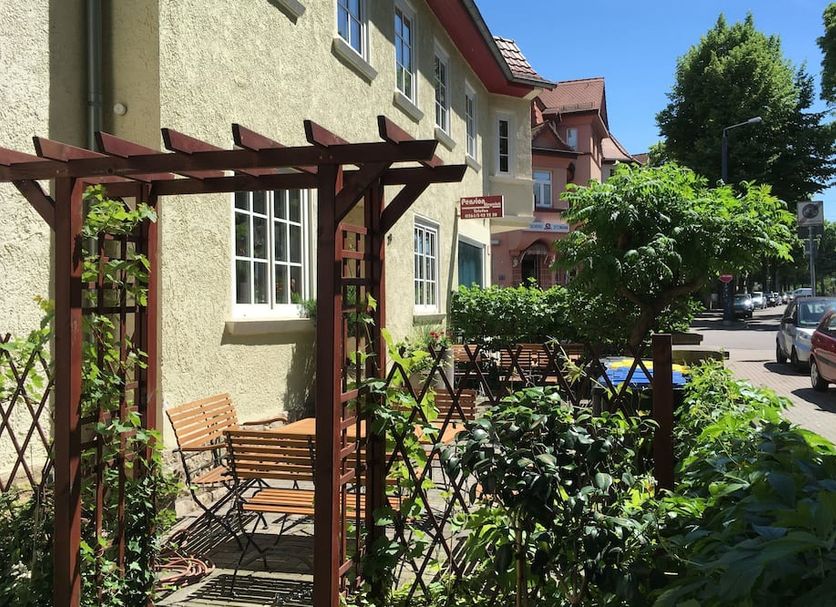 Pension Wegerich in Erfurt with outdoor garden seating beside the hotel and street view