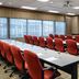 The Westin Southfield Detroit meeting room with red chairs, long conference tables, and projector screen