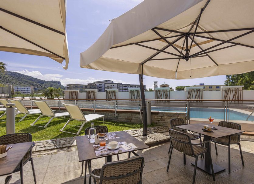Novotel Salerno Est Arechi terrace with poolside seating and mountain views in Salerno