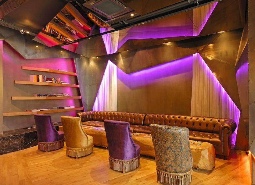 Tulip City Hotel & Spa in Istanbul lounge with tufted sofa, colorful chairs and purple ambient lighting