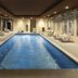 Indoor pool at Hyatt Place South Reno in Reno with lounge chairs and glass walls
