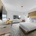 The Evergreen Hotel in McCall: modern guest room with king bed, wall-mounted TV, desk and window view