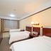 Hubin Bubugao Hotel in Qingyuan guest room with two beds, wall-mounted TV, and window curtains