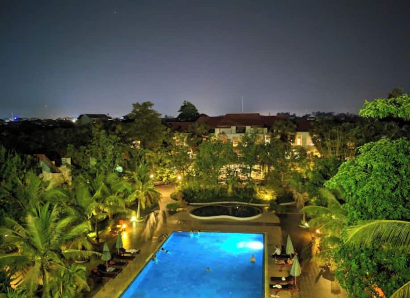 EG Paradise Angkor Villa Hotel in Siem Reap with lit outdoor pool and lush tropical garden at night