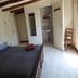 Au Pied Levé in Trévron guest room with wooden beams, double bed, and adjoining sink area