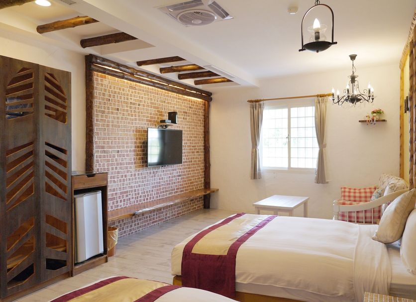 Kenting Sin Sin Hotel Iil room in Hengchun Township with brick accent wall, bed, window and seating area