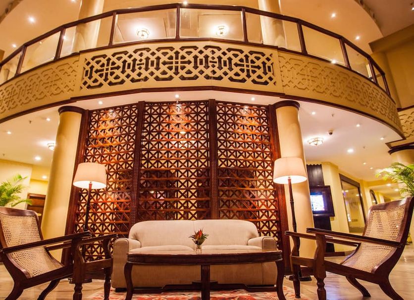 Southern Sun Dar es Salaam lobby with ornate carved wood screen, balcony railing and seating area