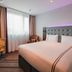 Premier Inn Karlsruhe City Am Wasserturm room with king bed, desk and window with curtains in Karlsruhe