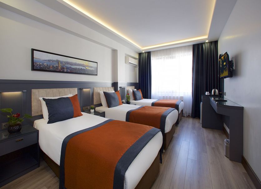 Hotel Eyfel Istanbul guest room with two twin beds, window light, and a sleek modern interior