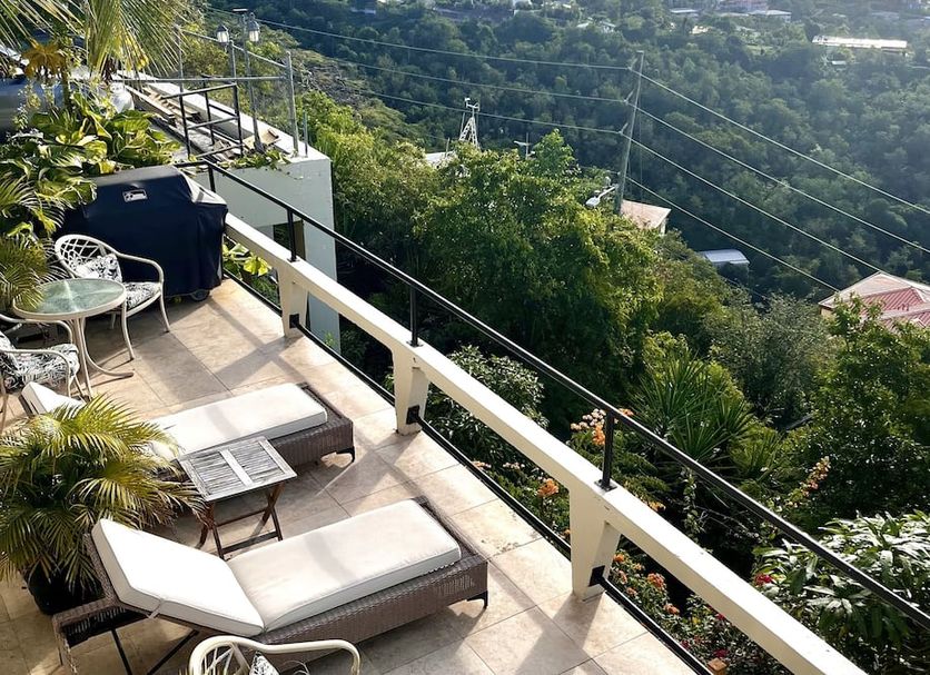 Island View Guesthouse in Saint Thomas Island balcony with lounge chairs and hillside sea views