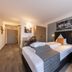 Tanneck hotel room in Bad Woerishofen with double bed, desk and armchair
