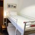La Caleta de Tamariu bunk bed room with window, wardrobe, and bedside table in Tamariu