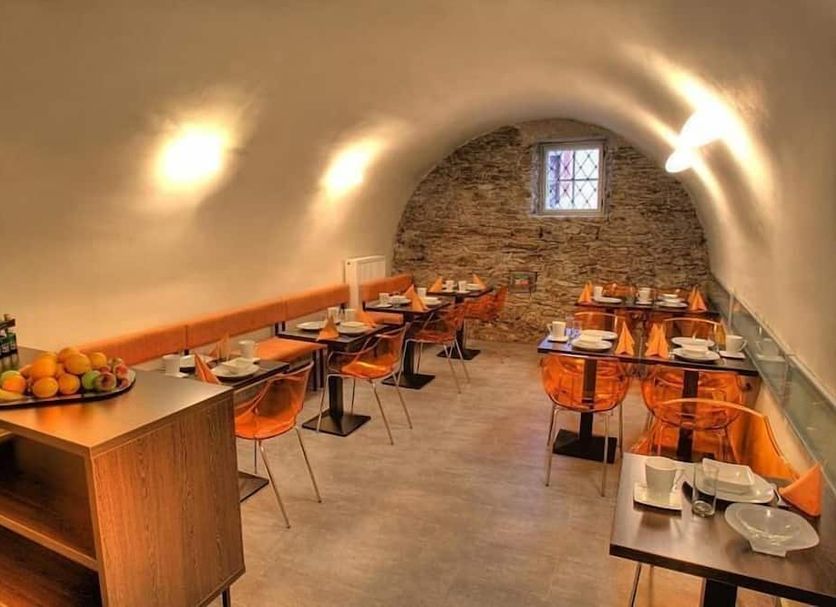 Hotel Svambersky dum in Český Krumlov dining room with stone wall, arched ceiling and set tables