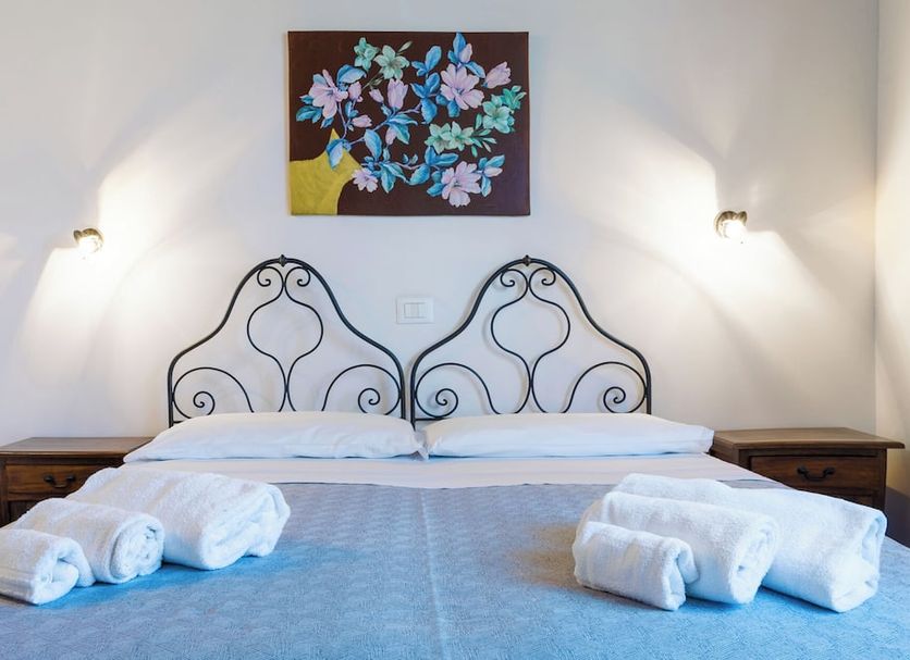 Casale Ginisara in Castellammare del Golfo: twin bed hotel room with floral wall art and bedside lamps