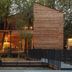 Terme Preistoriche Resort & Spa in Montegrotto Terme, wood-clad resort building with lit terrace among trees