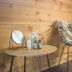 Basecamp Oulanka in Kuusamo: cozy lounge chair with fur throw beside a small table and mirror