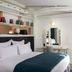 Hotel Louvre Montana Paris guest room with king bed, vanity, and window drapes