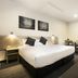 Nightcap at St Albans Hotel room with queen bed, bedside lamps, and small dining table in Saint Albans