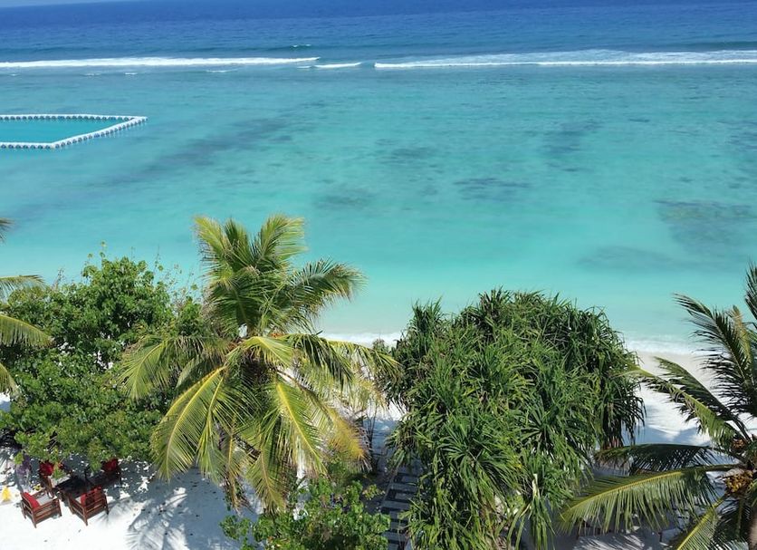 Vista Beach Retreat in Malé with turquoise ocean, palm trees, and a sandy beach