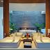 Naman Retreat Da Nang spa bathroom with dual sinks, soaking tub, stone wall, and indoor plants