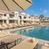 Solmar Resort Cabo San Lucas pool with lounge chairs and thatched palapa by oceanfront buildings